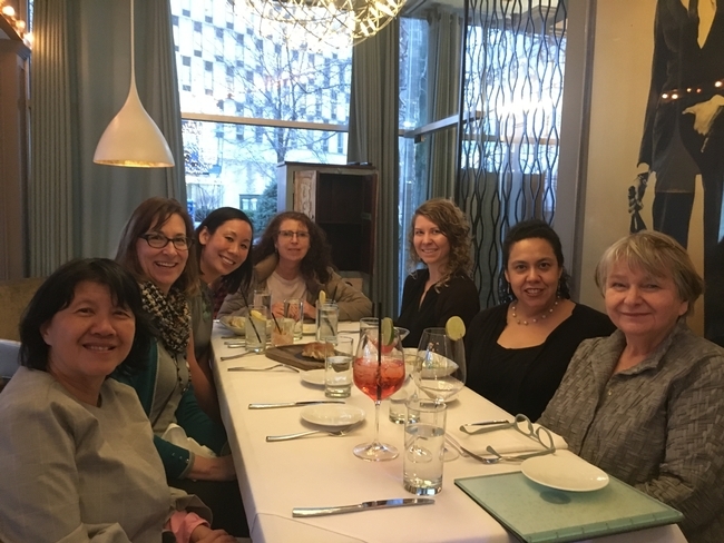 Gail Woodward-Lopez with colleagues seated around a table at a restaurant