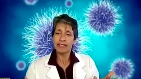 Dorina Espinoza, wearing a white suit jacket, appears on screen with blue images of coronavirus floating on the background.