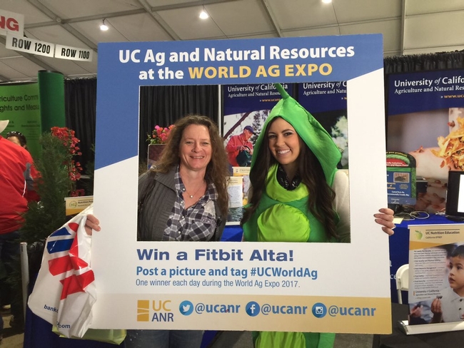 A visitor poses at World Ag Expo with Danielle Palermini, right, of Program Support Unit.