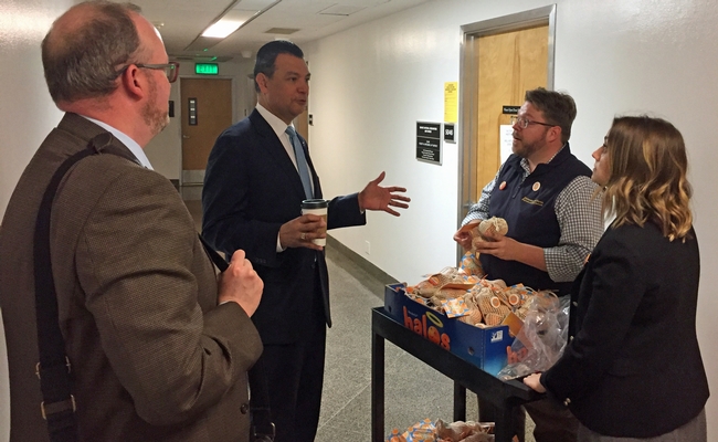 Secretary of State Alex Padilla, second from left, stopped Lucas Frerichs and Meredith Turner in the Capitol hallway to discuss mandarins.