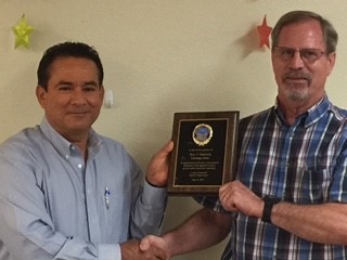 Imperial County Agricultural Commissioner Carlos Ortiz presents Eric Natwick a plaque on behalf of the Board of Supervisors.