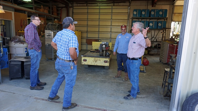 Mark Lagrimini views the shop at the West Side REC. Pictured, from left, are Lagrimini, West Side principal superintendent of agriculture Rafeal Solorio, senior farm machinery mechanic Mark Strole, and director Bob Hutmacher.