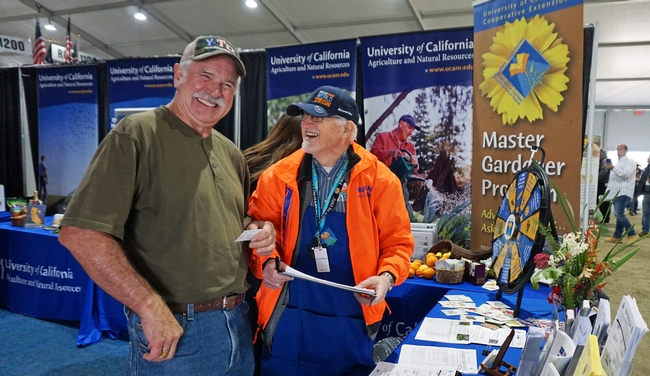 Tulare County UC Master Gardener, ______, shares a light moment with a booth visitor while answering gardening questions.