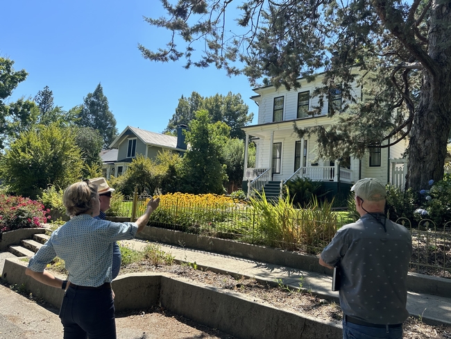 A UCCE advisor points to a house as she discusses home hardening options