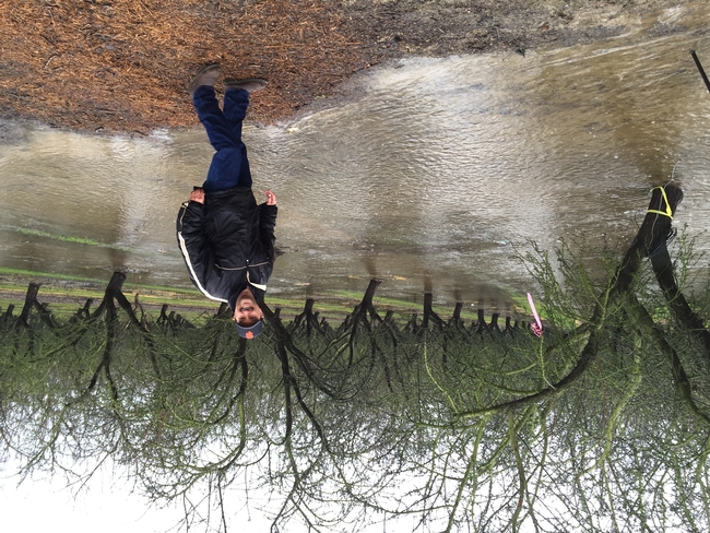 Roger smiles as he stands in a flooded dormant almond orchard