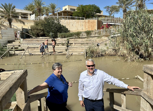 Glenda and Brent stand beside the river.