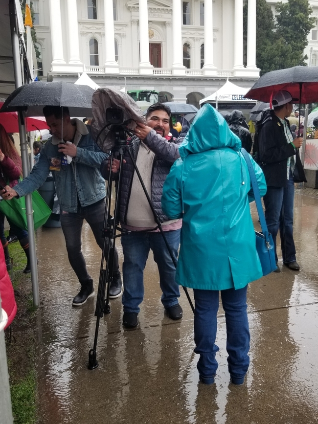 Strat Comm members Maguel Sanchez (with camera) and Pam Kan-Rice (in raincoat) do their thing!