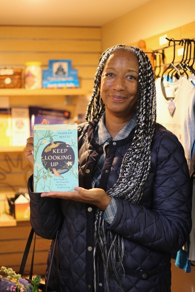 Tammah Watts posa con su libro Keep Looking Up: A Guide to the Powerful Healing of Birdwatching (Sigue mirando hacia arriba: una guía para la poderosa sanación con la observación de aves). Todas las fotografías por Saoimanu Sope.