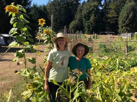 Residents Sojourna Lee and Ohi Vidaver pose in their 3 sisters plot on Meadow Farm