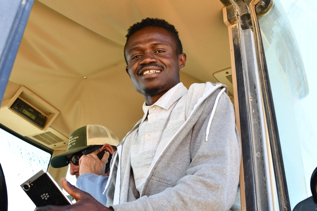 Francis Akolbila riding in the Five Points field station tractor with Jaime Solorio and learning about global positioning systems (GPS) guidance