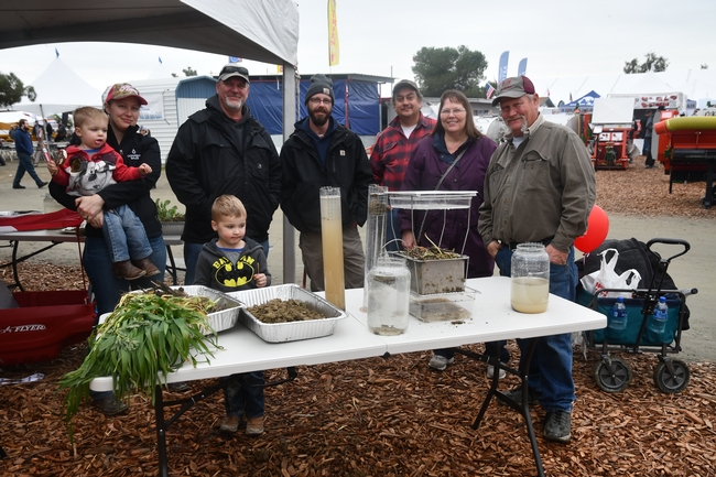 Family visiting the CASI / NRCS information display site at the 2019 World Ag Expo in Tulare, CA