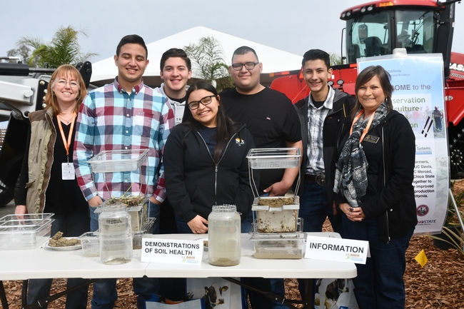Mira Dick, USDA NRCS Merced (far left) and Sheryl Feit, USDA NRCS Davis (far right) conduct soil health demonstation at the joint CASI and NRCS display site at the 2019 World Ag Expo in Tulare, CA