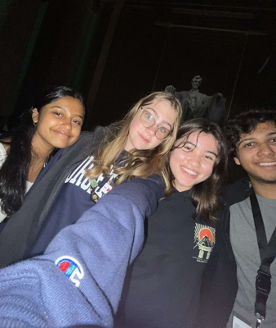 4 youth posing in a selfie with a dark background