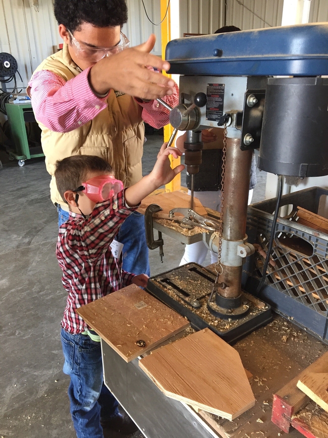 Youth volunteer assisting with woodworking project.