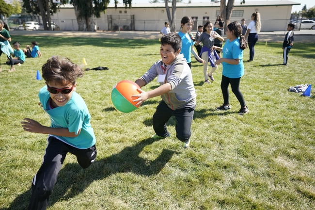 Students engaged in physical activity while teaching youth their unique versions of tag, created in the Program Your Playground activity.