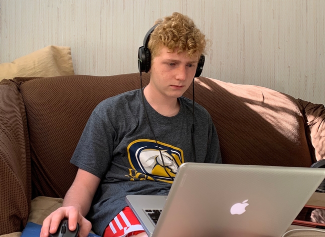 Youth with headphones looking at laptop screen