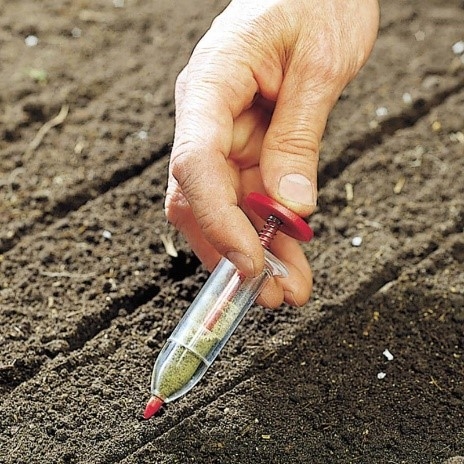 Hand planting seeds with a Spring Loaded Seed Dispenser