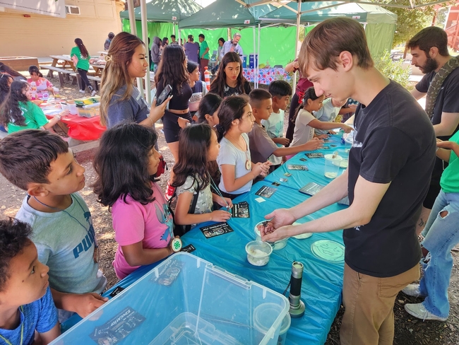 A volunteer shows spiders and other creatures to students