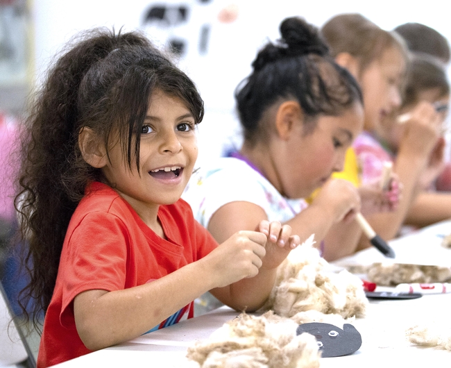A girl smiles during an arts and crafts activity