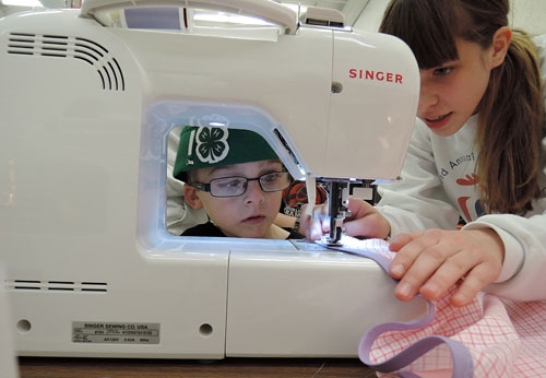 Wyatt Morris, 6, of the Vaca Valley 4-H Club, Vacaville, learns how to sew a 