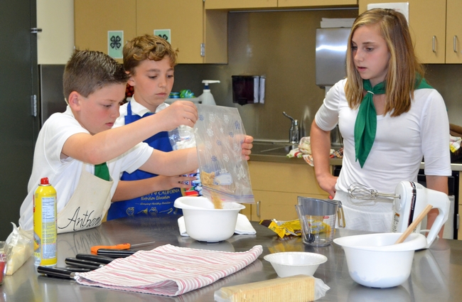 Elisabeth Watkins, winner of the 2019 4-H Youth in Action Award for Healthy Living, mentoring younger 4-H member on a cooking project.