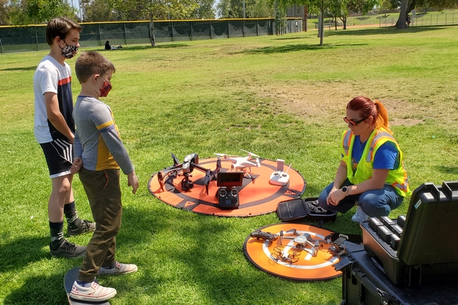 4-H youth look at a drone