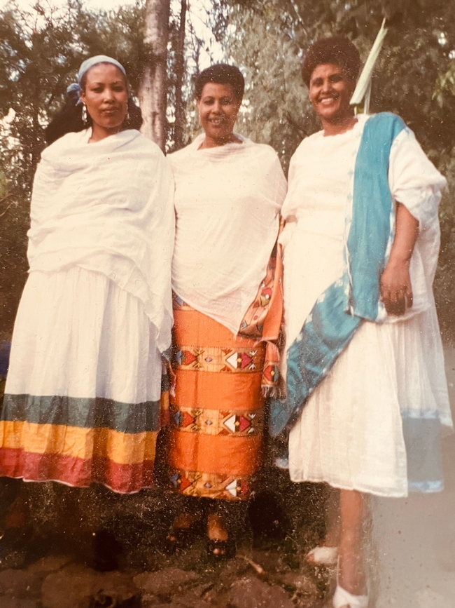 Three black women dressed in traditional Ethiopian attire.