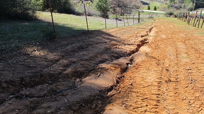 a clay farm road with deep rilling
