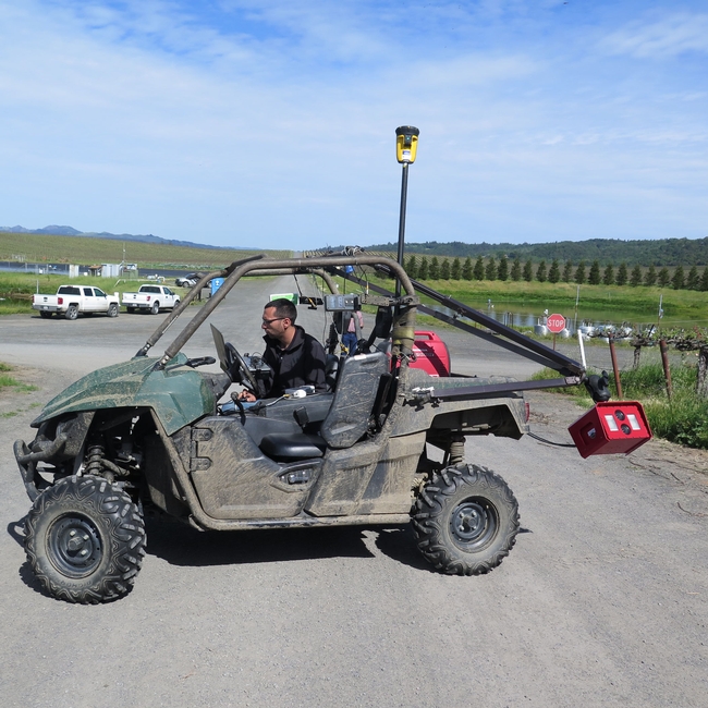 A man with an ATV and equipment mounted