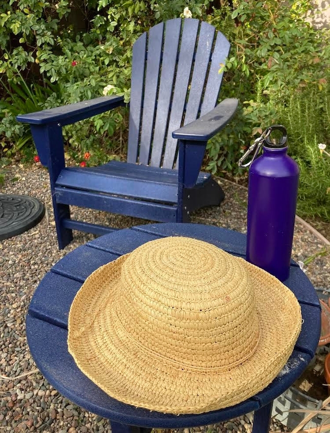 A wide-brimmed hat, water, and shady place to sit are essential for gardening in the summer! (Photo: Ann Edahl)