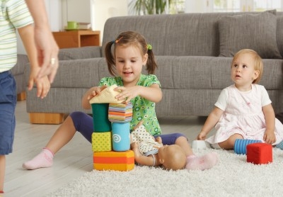 Children playing on the floor with a couch in the background