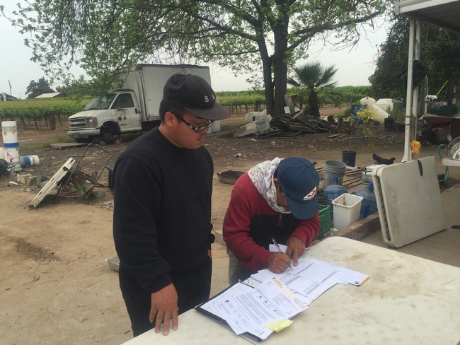Xia Yang works with a Hmong farmer on making changes to energy billing.