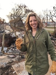A homeowner holds a foundation vent found in the rubble of her home. Her house, built before the 2008 construction standards, had ¼-inch mesh screen that may have allowed embers to enter her home.