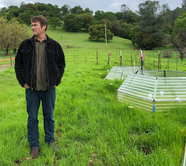 SFREC director Jeremy James stands next to a small chamber designed to simulate effects of warming air and soil temperatures on rangeland grasses.  The poly carbonate hexagons slow rates of heat loss form plots, allowing scientists to artificially warm plants and soils in the chambers. (Photo: Linda Forbes)