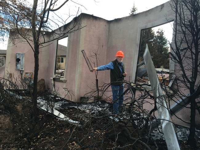 Steve Quarles and Yana Valachovic examined houses in Paradise after the devastating 2018 Camp Fire. Quarles holds up a vent screen that may have allowed embers to enter the house. Photo by Yana Valachovic