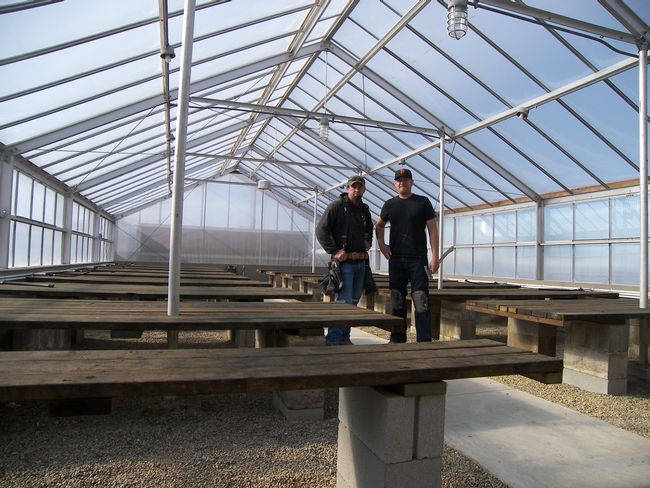 Physical Plant Mechanic Dan Seymore and assistant Dave Christiansen proudly show off the new greenhouse