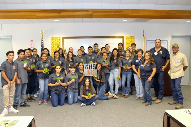 Woodlake Ag Academy students show off a plaque created in the ag mechanics workshop and take home some Buddha's Hand citrus fruit.