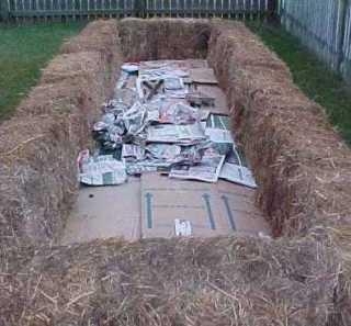 Straw bale garden perimeter with cardboard mulch underneath.