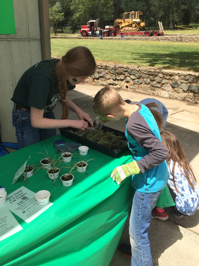 McKenna helping a youth plant