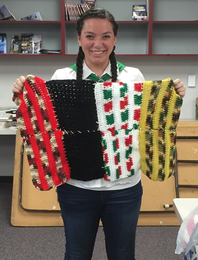 Lydia holding a blanket assembled by 4-H Youth