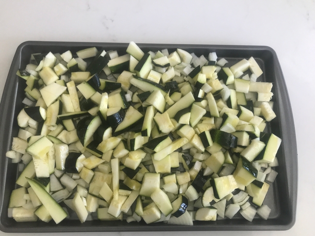 Cut up zucchini and other veggies and place in pan with sides.