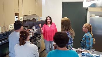 training class, students in a commercial kitchen listening to the instructor