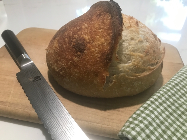 sourdough boule with bread knife and towel