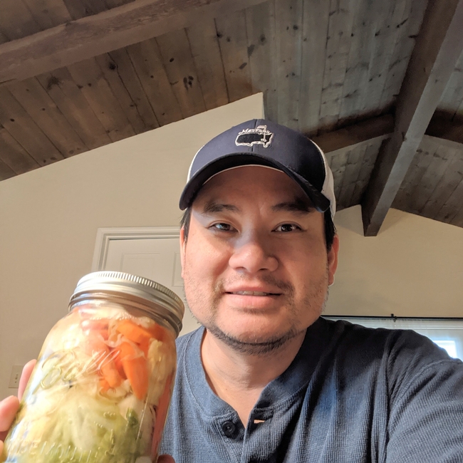 Kit Leung showing vegetables he grew and pickled Vietnamese style.