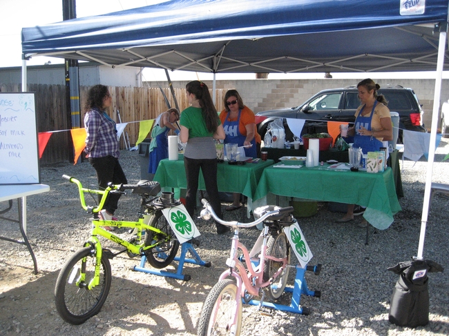 4-H Teens talk about nutrition with kids and demonstrate how to ride the Smoothy Bikes.