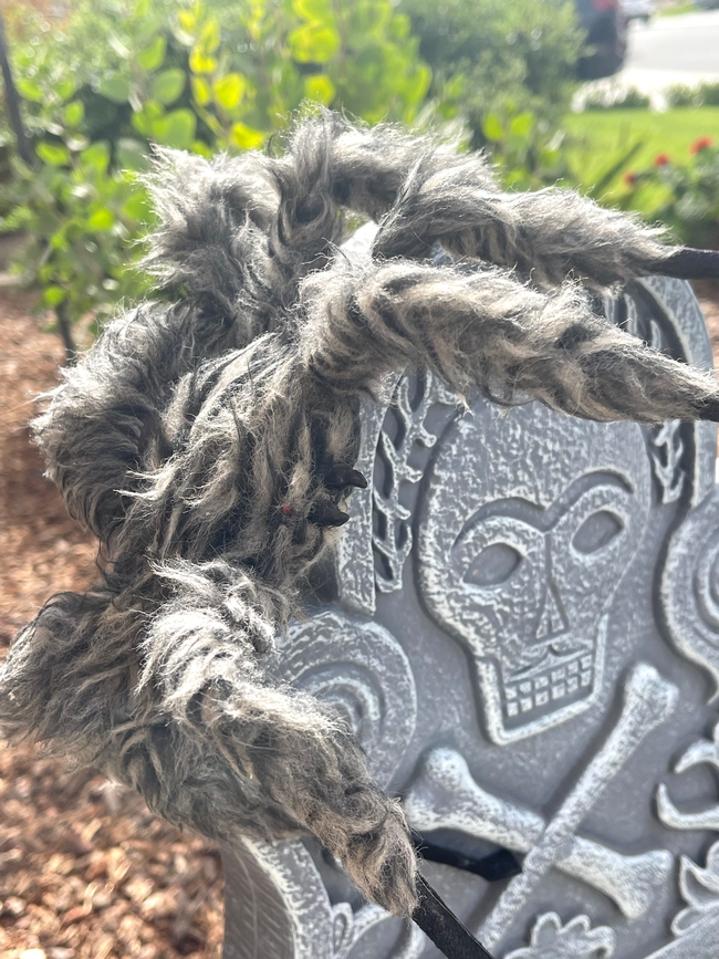 Fake spider crawling over a fake gravestone.