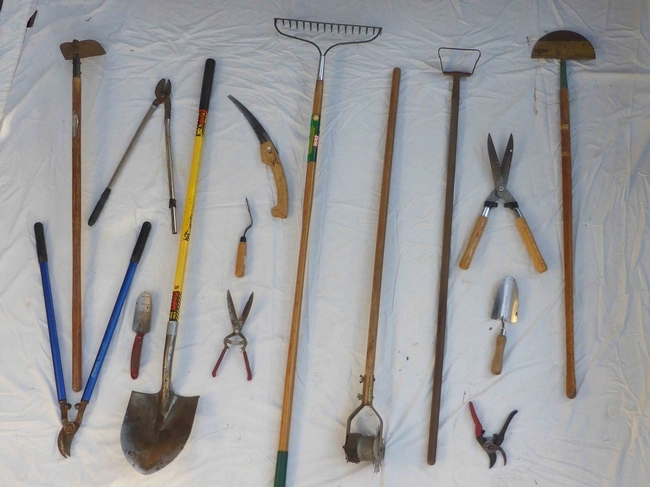 An assortment of tools including pruners, shovels, and hoes.