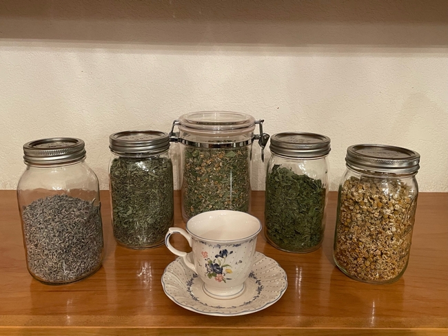 Clear jars filled with dried tea leaves and flowers.
