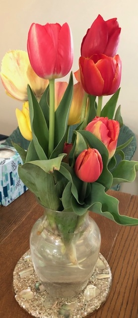 Yellow, red and pink flowers in a vase.