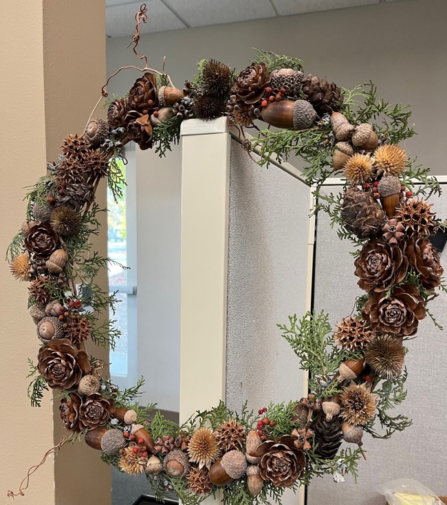 wreath made with grapevines, decorated with pinecones.